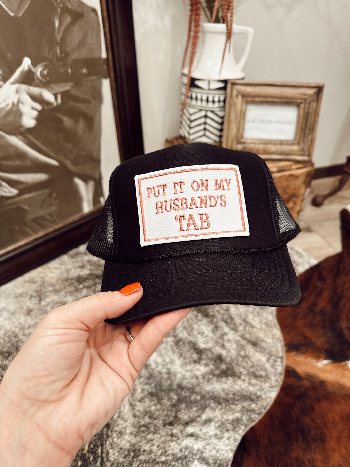 Put It On My Husband's Tab Trucker in Black